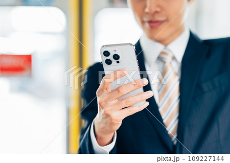 通勤電車でスマホを見るビジネスマン　撮影協力「京王電鉄株式会社」 109227144
