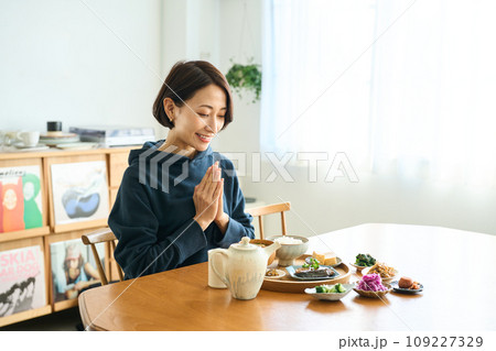 朝食をいただく前に手をあわせる女性 109227329