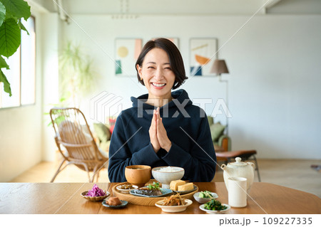 朝食をいただく前に手をあわせる女性 109227335