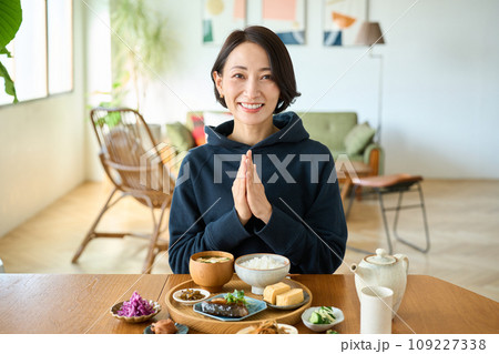 朝食をいただく前に手をあわせる女性 朝食をいただく前に手をあわせる女性 109227338