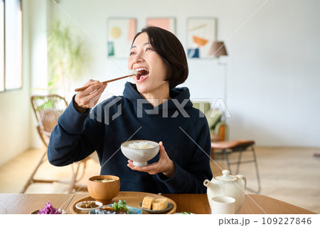 茶碗によそったご飯を食べる女性 109227846