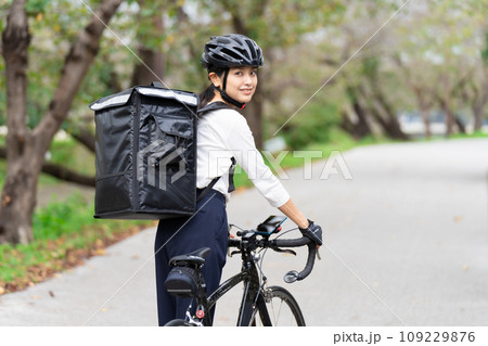 ロードバイクでフードデリバリー配達員をする若い女性の写真素材 [109229876] - PIXTA