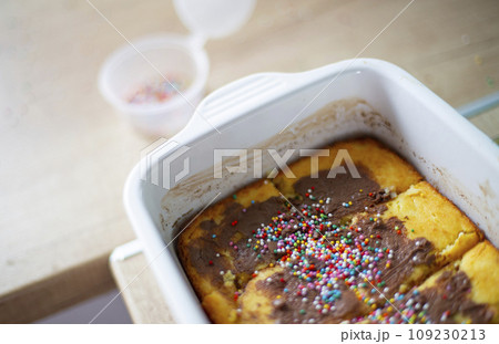 Sweet cake decorated with multi-colored balls in a white ceramic form Sweet cake decorated with multi-colored balls in a white ceramic form 109230213