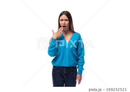 young well-groomed brunette woman dressed in a blue cardigan yawns on a white background with copy young well-groomed brunette woman dressed in a blue cardigan yawns on a white background with copy 109232521