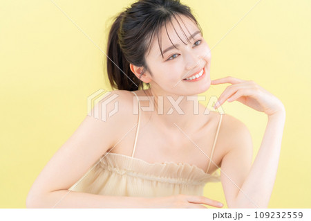 イエローバックでスキンケアをする若い女性 109232559