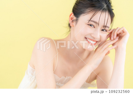 イエローバックでスキンケアをする若い女性 109232560