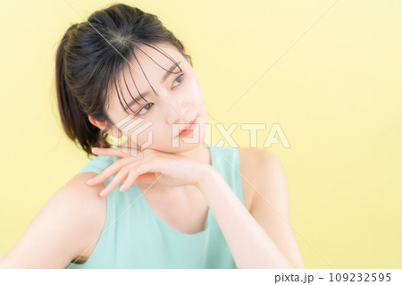イエローバックでスキンケアをする若い女性 109232595