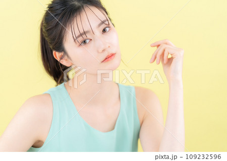イエローバックでスキンケアをする若い女性 イエローバックでスキンケアをする若い女性 109232596