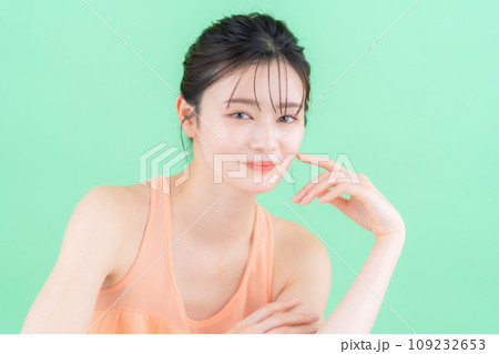グリーンバックでスキンケアをする若い女性 109232653