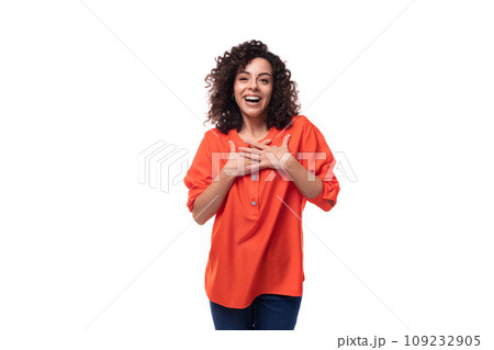 young curly brunette woman dressed in an orange blouse on a white background 109232905