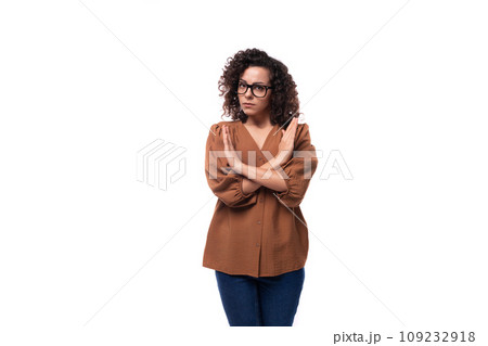 young curly brunette woman dressed in brown blouse shows disagreement gesture young curly brunette woman dressed in brown blouse shows disagreement gesture 109232918