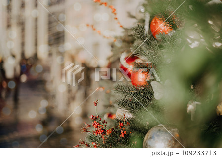Close up of balls on christmas fir tree. Bokeh light garlands in background with copy space. Merry christmas and happy new year. 109233713