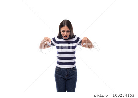 young european lady with black even hair dressed in a striped t-shirt points with her index finger young european lady with black even hair dressed in a striped t-shirt points with her index finger 109234153