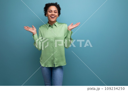 young bright cheerful latin woman dressed in a green blouse on the background with copy space 109234250
