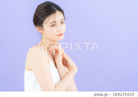 パープルバックでスキンケアをする若い女性 109235035