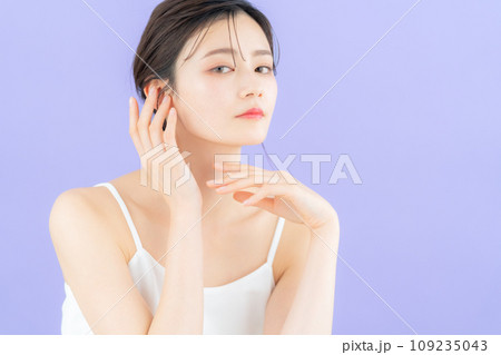 パープルバックでスキンケアをする若い女性 109235043