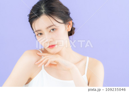 パープルバックでスキンケアをする若い女性 109235046