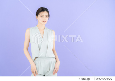 パープルバックでポーズを取る若い女性のファッションモデル 109235455