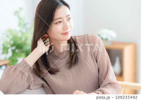 リビングのソファでくつろぐ若い女性 リビングのソファでくつろぐ若い女性 109235492