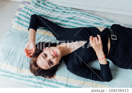 Beautiful woman lying on sleeping mattress on the floor Beautiful woman lying on sleeping mattress on the floor 109236413