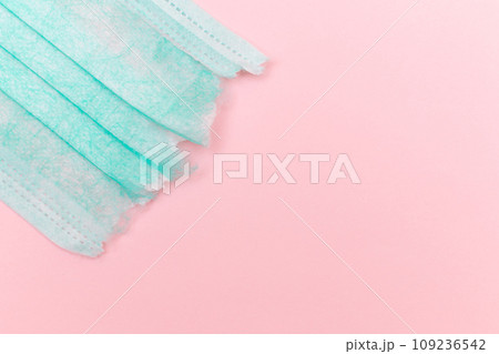 Green Torn Medical Face Mask on the Pink Background Green Torn Medical Face Mask on the Pink Background 109236542