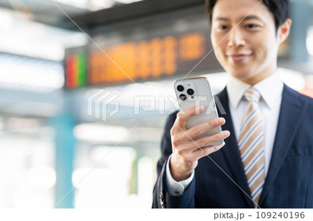 駅でスマホを見るビジネスマン　撮影協力「京王電鉄株式会社」 109240196