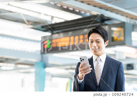 駅でスマホを見るビジネスマン　撮影協力「京王電鉄株式会社」 109240724