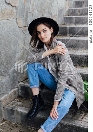 Beautiful brunette woman in hat walking in autumn city Beautiful brunette woman in hat walking in autumn city 109241228