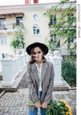 Beautiful brunette woman in hat walking in autumn city Beautiful brunette woman in hat walking in autumn city 109241229