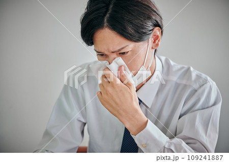 ティシュで鼻水を拭くYシャツ姿の男性会社員 109241887