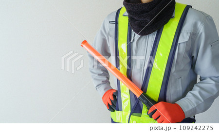 ネックウォーマーで防寒対策｜誘導灯を持つ誘導員イメージ 109242275