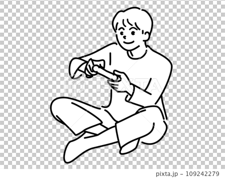 A boy sitting cross-legged and playing a game A boy sitting cross-legged and playing a game 109242279