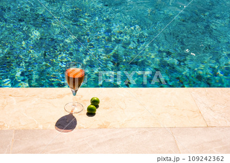 Glass of pink wine and yellow sunglasses at the pool. 109242362