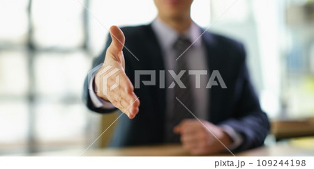 Businessman in suit extending his hand for handshake to partner at work in office closeup 109244198
