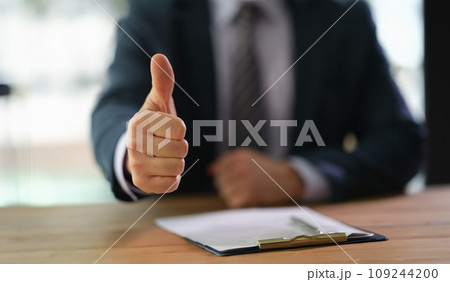 Businessman showing thumb up at work in office closeup 109244200