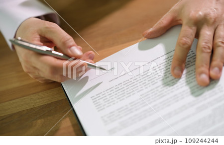 Hands of businessman with pen signing contract document at table closeup 109244244