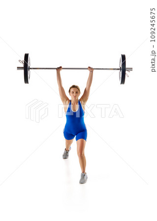 Competition. Full-length of young woman in sportswear, lifting heavy barbell against white background 109245675