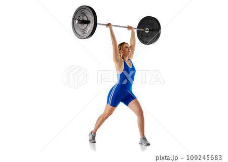 Young girl with fit strong body, athlete training, lifting heavy weights, barbell against white background 109245683