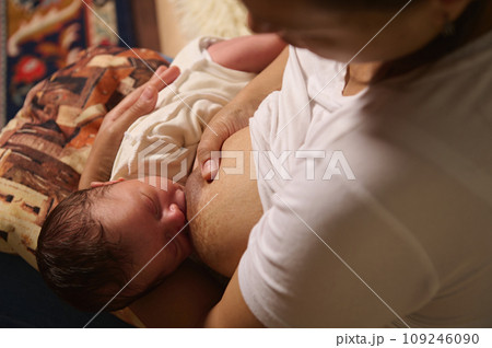 Authentic close-up portrait of loving mother breastfeeding her baby for health, nutrition and wellness at home. Authentic close-up portrait of loving mother breastfeeding her baby for health, nutrition and wellness at home. 109246090