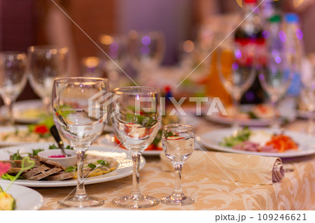 Served festive table with snacks, glasses, glasses, cutlery and napkins for a banquet Served festive table with snacks, glasses, glasses, cutlery and napkins for a banquet 109246621