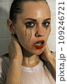 Portrait of a young girl looking at camera with dripping makeup standing in the shower. Vertical Shot Portrait of a young girl looking at camera with dripping makeup standing in the shower. Vertical Shot 109246721