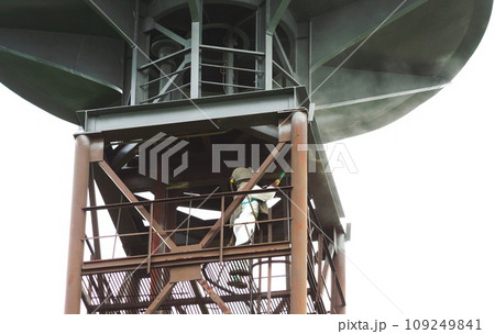 Sand blasting process. Industrial worker in protective uniform cleaning surface of big steel construction before painting on high altitude. 109249841