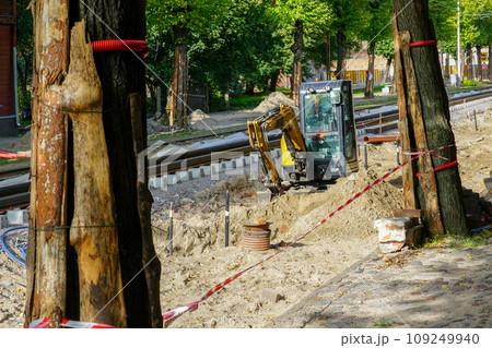 Street and tram track rebuilding view, protection of tree trunks from damage with board covers Street and tram track rebuilding view, protection of tree trunks from damage with board covers 109249940