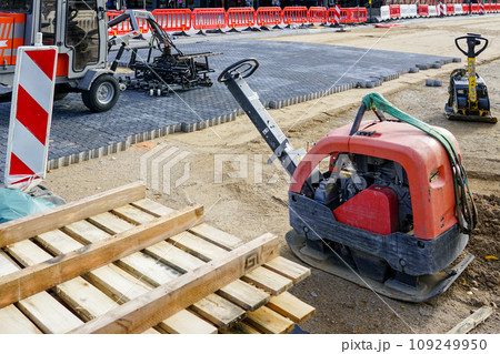 Repaved place, mobile plate compactors, block laying machine, warning signs, plastic barriers Repaved place, mobile plate compactors, block laying machine, warning signs, plastic barriers 109249950