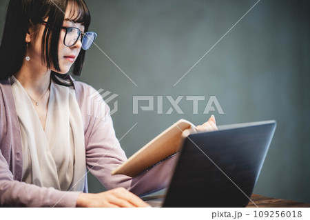 カフェ風のテーブルで仕事をしている女性 カフェ風のテーブルで仕事をしている女性 109256018