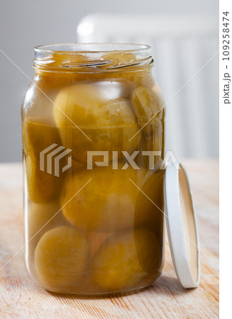 Glass jar with salted green tomatoes 109258474