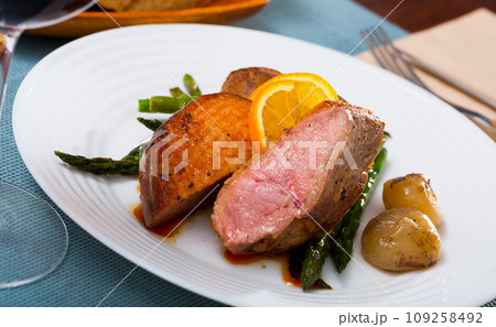 Grilled duck breast with asparagus and fried onions 109258492