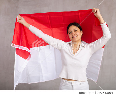 Pretty young female student holding Indonesia flag in her hands 109258604