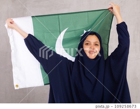 Young woman in hijab posing with Pakistan flag 109258673