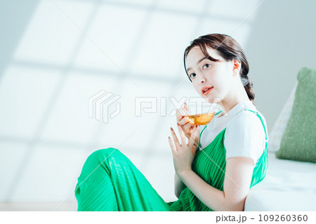 部屋でお茶を飲む若い女性。 部屋でお茶を飲む若い女性。 109260360